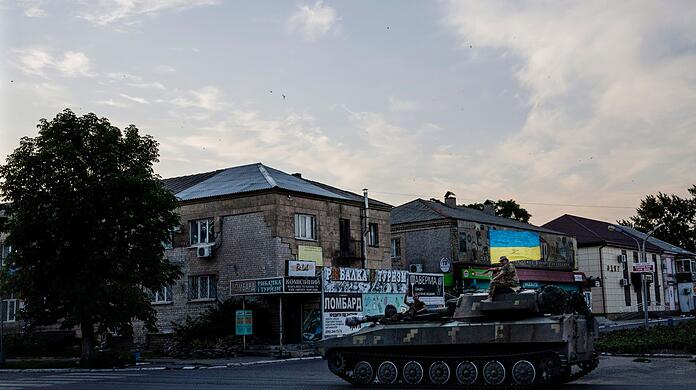Ukrainische Soldaten fahren auf einem Panzer durch eine Straße im ostukrainischen Pokrovsk.