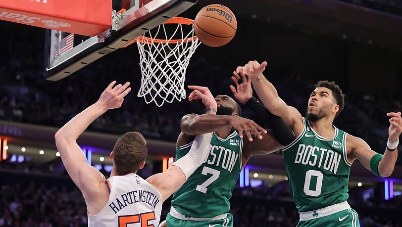 Celtics-Forward Jayson Tatum (0) blockt den Ball von New York Knicks-Center Isaiah Hartenstein (55), während Jaylen Brown (7) verteidigt.