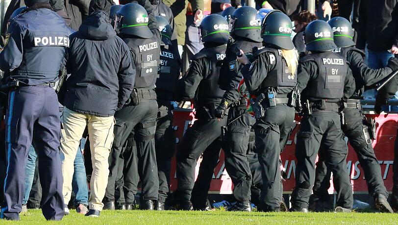 Polizisten stehen vor dem Bayern-Fanblock.