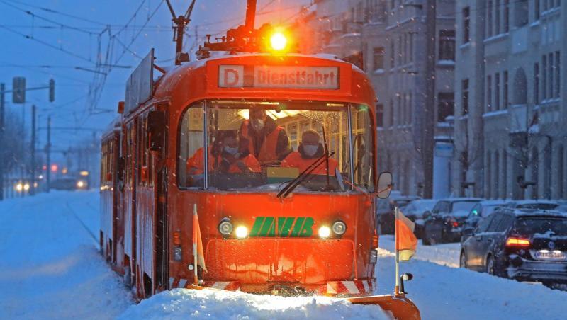 Eine Straßenbahn mit Schneepflug der Magdeburger Verkehrsbetriebe befreit die Gleise von Schnee und Eis.