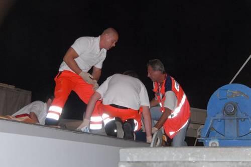 Sanitäter kümmern sich um den Verletzten auf dem Dach des Wohnwagens, so lange steht das Riesenrad still.