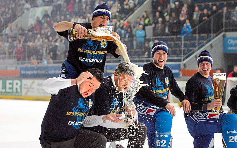 EHC-Kapitän Andreas Raubal duscht Trainer Pat Cortina (li.) und Manager Christian Winkler (2.v.li.) nach dem Gewinn des DEB-Pokals 2009.