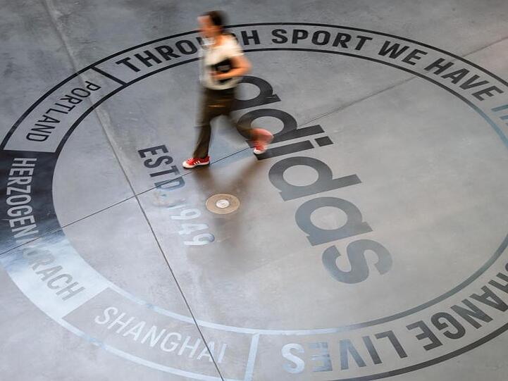 Ein großes Logo des Sportartikelherstellers "adidas" ist auf dem Boden eines Bürogebäudes zu sehen. Foto: Nicolas Armer/Archivbild