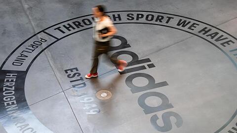 Ein großes Logo des Sportartikelherstellers "adidas" ist auf dem Boden eines Bürogebäudes zu sehen. Foto: Nicolas Armer/Archivbild