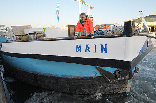 Wolfgang Mayer auf seiner &bdquo;Main&ldquo; im Nürnberger Hafen: Er und seine Crew kämpfen täglich gegen die immer dicker werdende Schicht, die den Rumpf einzuschließen droht.