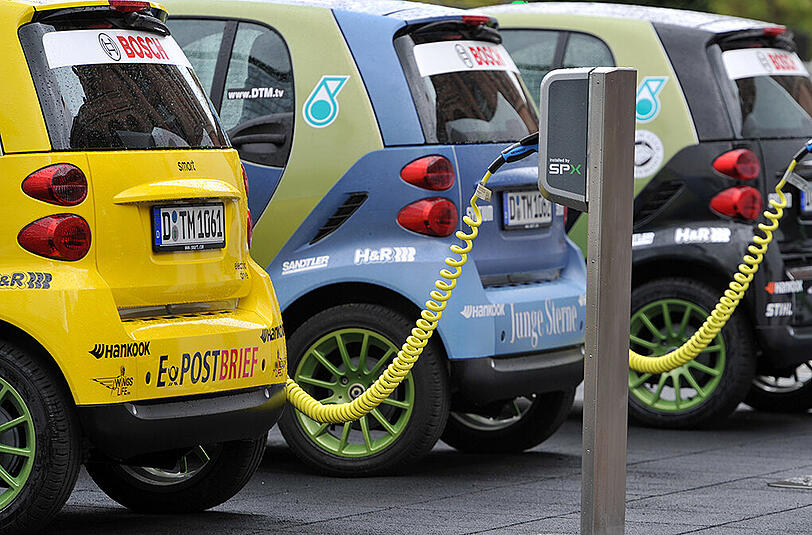 Elektro-Smarts stehen an den Säulen einer Stromtankstelle. Während sich in Fuhrparks mancher Firmen und Behörden immer mehr E-Autos finden, steigen die Autofahrer privat noch eher weniger auf Elektromobilität um.