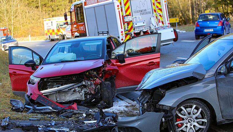 Zwei schwer beschädigte Autos stehen an einer Straße.