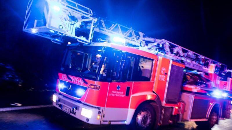 Ein Drehleiterwagen der Feuerwehr fährt mit Blaulicht über eine Straße. Foto: Marcel Kusch/dpa/Symbolbild