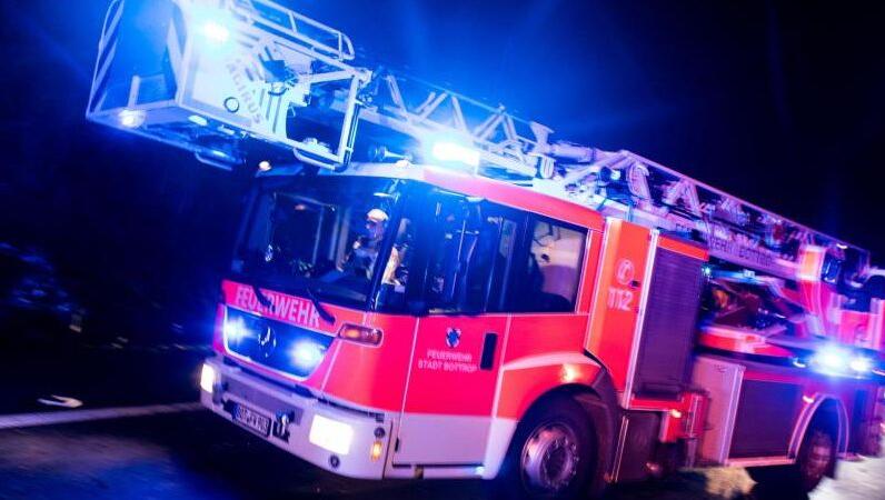 Ein Drehleiterwagen der Feuerwehr fährt mit Blaulicht über eine Straße. Foto: Marcel Kusch/dpa/Symbolbild
