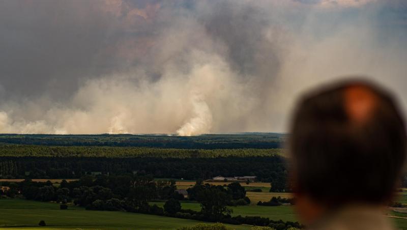 Ein Mann blickt von einem Aussichtsturm von Niedersachsen aus über die Elbe auf den Waldbrand bei Lübtheen in Mecklenburg-Vorpommern. Ein Mann blickt von einem Aussichtsturm von Niedersachsen aus über die Elbe auf den Waldbrand bei Lübtheen in Mecklenburg-Vorpommern.