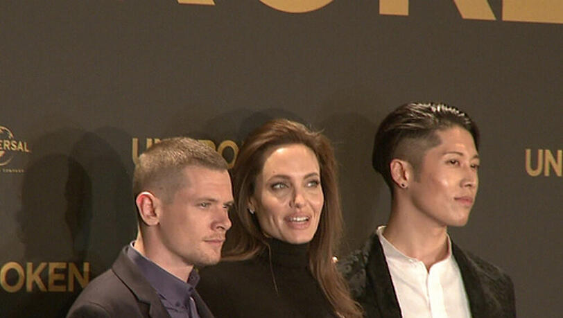 Angelina Jolie (m.) zwischen zwei Darstellern aus ihrem Film "Unbroken" Angelina Jolie (m.) zwischen zwei Darstellern aus ihrem Film "Unbroken"