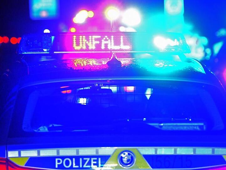 Blaulicht und der LED- Schriftzug "Unfall" auf dem nassen Dach eines Streifenwagens. Foto: Stefan Puchner/dpa/Symbolbild