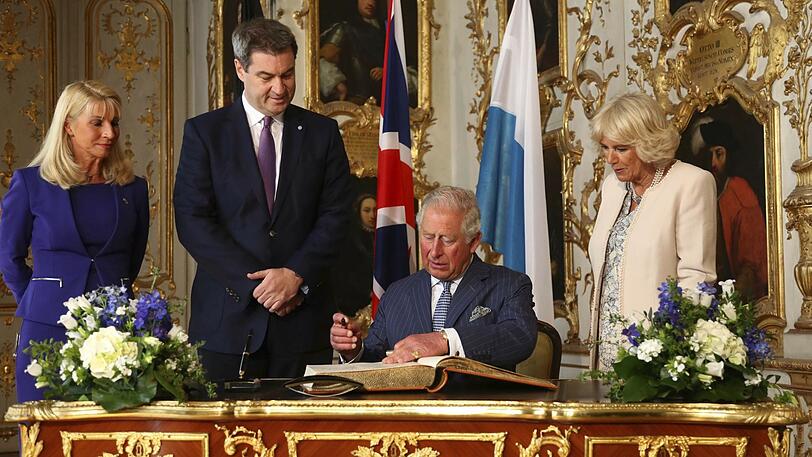 Charles und Chamilla tragen sich ins Goldene Buch der Residenz ein.