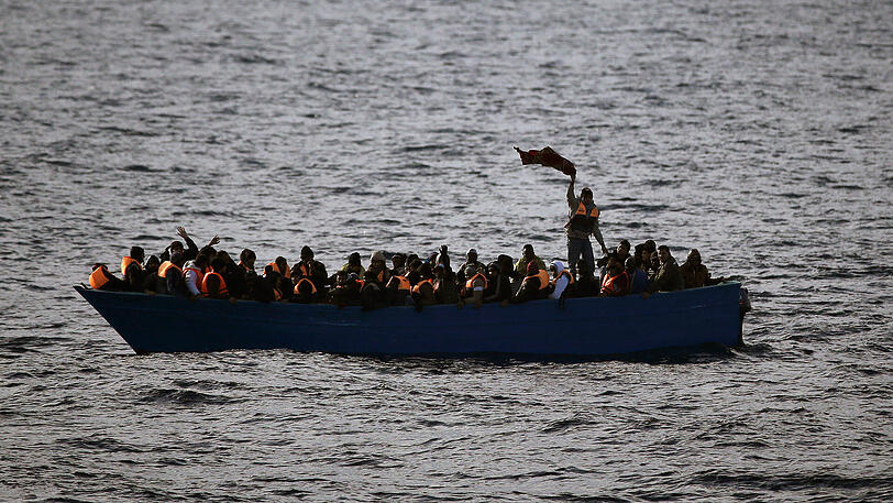 Flüchtlinge in einem Boot rufen auf dem Mittelmeer um Hilfe. (Archivbild)