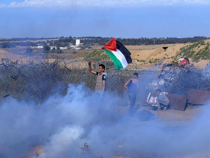 Palästinensische Demonstranten zeigen eine palästinensische Flagge an der Grenze zwischen Gaza und Israel.