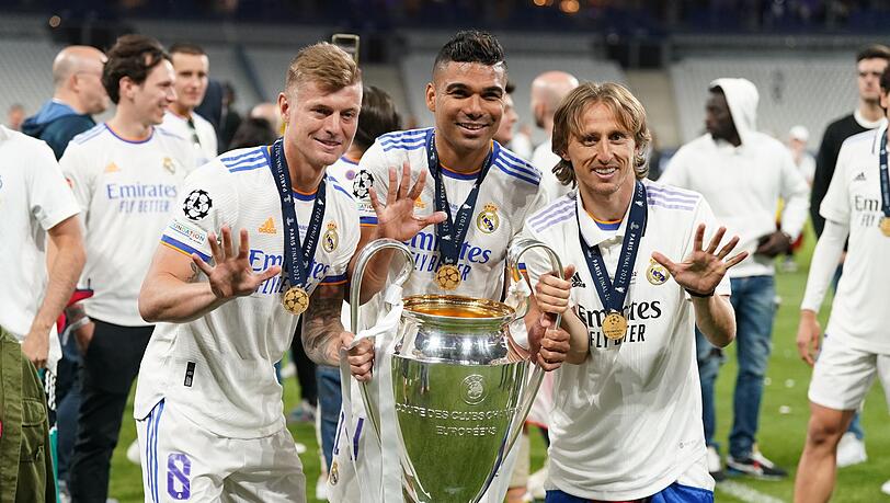 Toni Kroos (l), Carlos Casemiro (M) und Luka Modric von Real Madrid jubeln mit der Trophäe nach dem Sieg. Toni Kroos (l), Carlos Casemiro (M) und Luka Modric von Real Madrid jubeln mit der Trophäe nach dem Sieg.