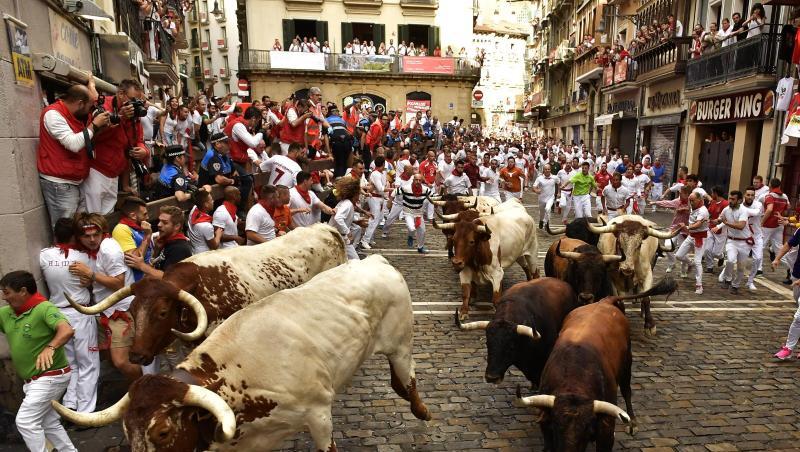 Stierläufer mit roten Halstüchern und roten Schärpen rennen während des San Fermin Festivals mit den Tieren mit. Stierläufer mit roten Halstüchern und roten Schärpen rennen während des San Fermin Festivals mit den Tieren mit.