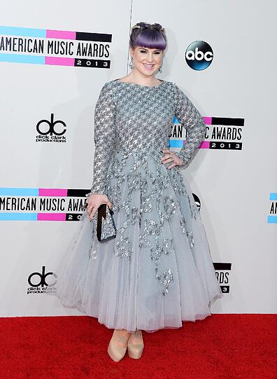 Da hilft selbst das breiteste Grinsen nichts: Die lilafarbenen Haare und der Tutu-Albtraum in Silber lassen Kelly Osbourne nicht gut aussehen.