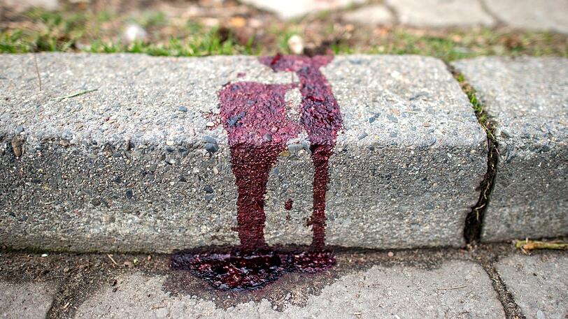 Blut auf einem Bürgersteig am Tatort in Burgwedel. Eine Frau ist bei einer Messerattacke lebensgefährlich verletzt worden.