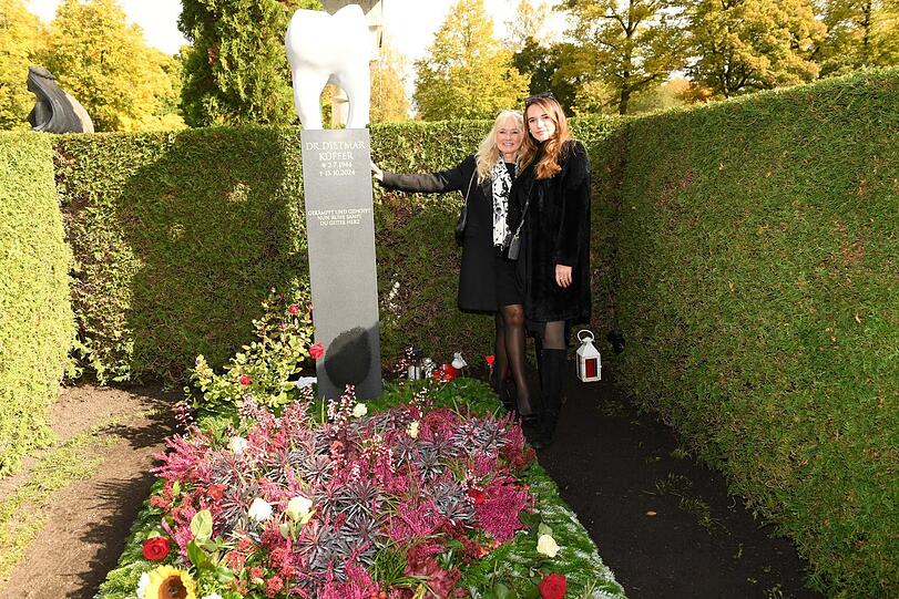 Larissa Küffer (r.) und Mutter Marion Küffer mit dem neuen Backenzahn-Denkmal am Grab von Didi Küffer († 80) auf dem Münchner Nordfriedhof.