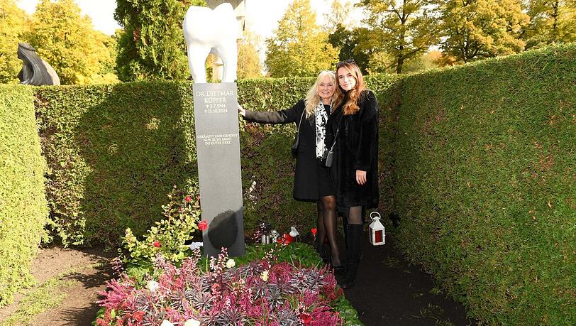 Larissa Küffer (r.) und Mutter Marion Küffer mit dem neuen Backenzahn-Denkmal am Grab von Didi Küffer († 80) auf dem Münchner Nordfriedhof.