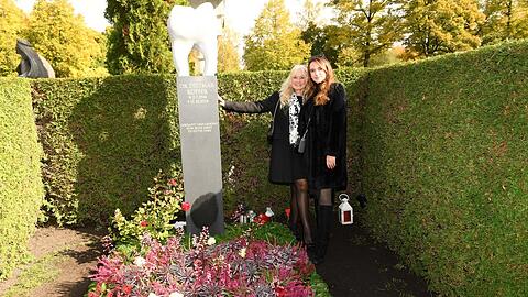 Larissa Küffer (r.) und Mutter Marion Küffer mit dem neuen Backenzahn-Denkmal am Grab von Didi Küffer († 80) auf dem Münchner Nordfriedhof.
