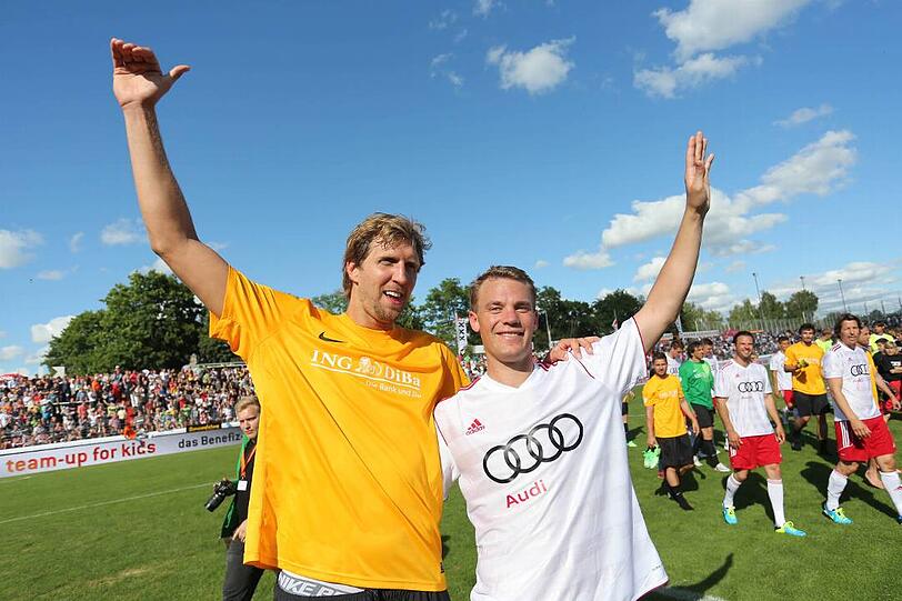 Basketballspieler Dirk Nowitzki (l.) und Fußball-Nationaltorwart Manuel Neuer bedanken sich nach dem Benefiz-Fußballspiel "Manuel Neuer & Friends - Nowitzki Allstars" in Würzburg bei den Zuschauern. Der Erlös der Veranstaltung kommt dem Projekt "Fußball trifft Kultur" der internationalen Kampagne LitCam zugute.