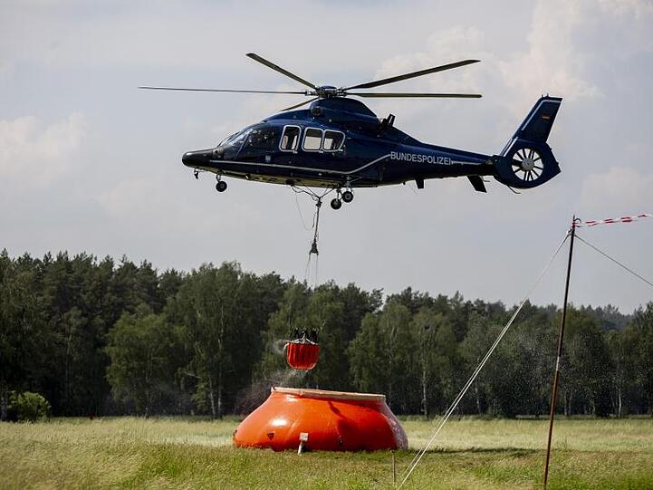 Ein Hubschrauber der Bundespolizei nimmt in Frankenförde Löschwasser auf. In Frankenförde bei Jüterbog befindet sich die Einsatzzentrale der Feuerwehr.