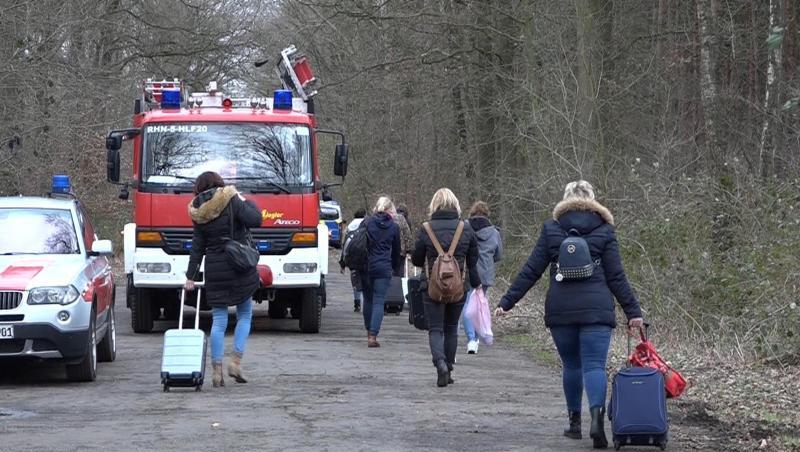 Bahnreisende ziehen ihre Rollkoffer über eine Straße bei Rheine. 200 Reisende mussten wegen einer gesperrten Bahnstrecke in Busse umsteigen. Bahnreisende ziehen ihre Rollkoffer über eine Straße bei Rheine. 200 Reisende mussten wegen einer gesperrten Bahnstrecke in Busse umsteigen.