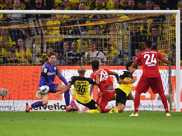 Dortmunds Torhüter Marwin Hitz (l) pariert glänzend einen Schuss von Bayerns Kingsley Coman (M).