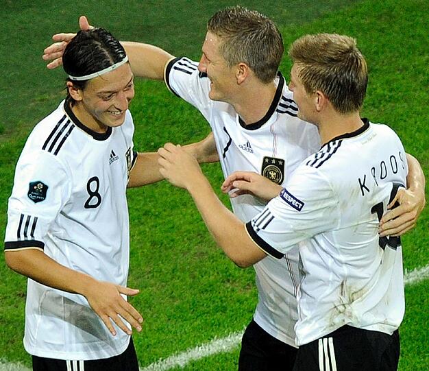 Die Mitte, das Herz des deutschen Spiels - verteilt auf drei Schrittmacher: Mesut Özil (l.) feiert hier das 6:2 gegen Österreich in der EM-Qualifikation mit Bastian Schweinsteiger und Toni Kroos.