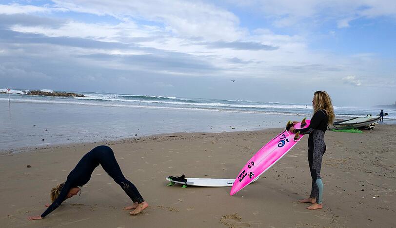 Surfen in Israel. Zwei Frauen bereiten sich auf ihren Wellenritt im Mittelmeer vor.