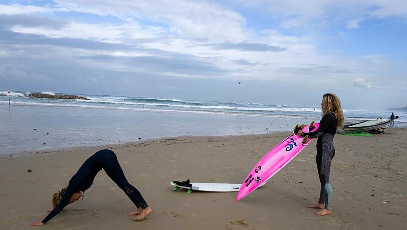 Surfen in Israel. Zwei Frauen bereiten sich auf ihren Wellenritt im Mittelmeer vor. Surfen in Israel. Zwei Frauen bereiten sich auf ihren Wellenritt im Mittelmeer vor.