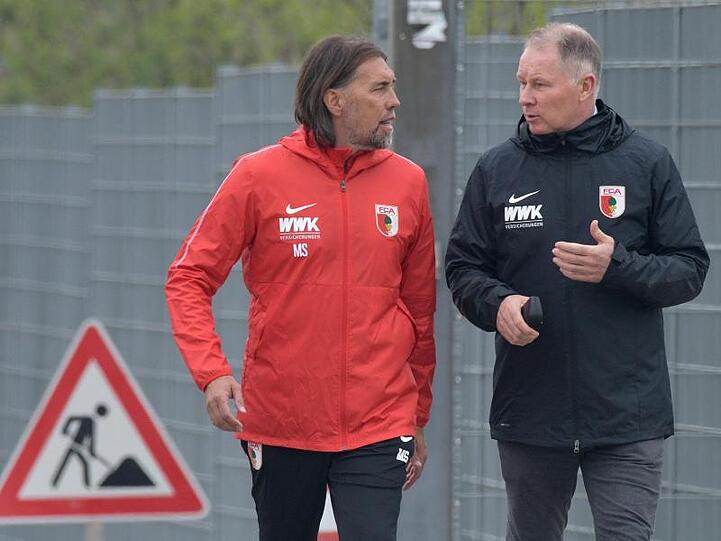 An seinem ersten Arbeitstag geht Augsburgs neuer Trainer Martin Schmidt (l) mit Sportdirektor Stefan Reuter zum Übungsgelände.
