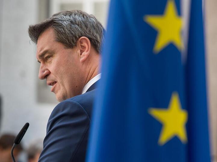 Bayerns Ministerpräsident Söder hinter einer Europafahne.