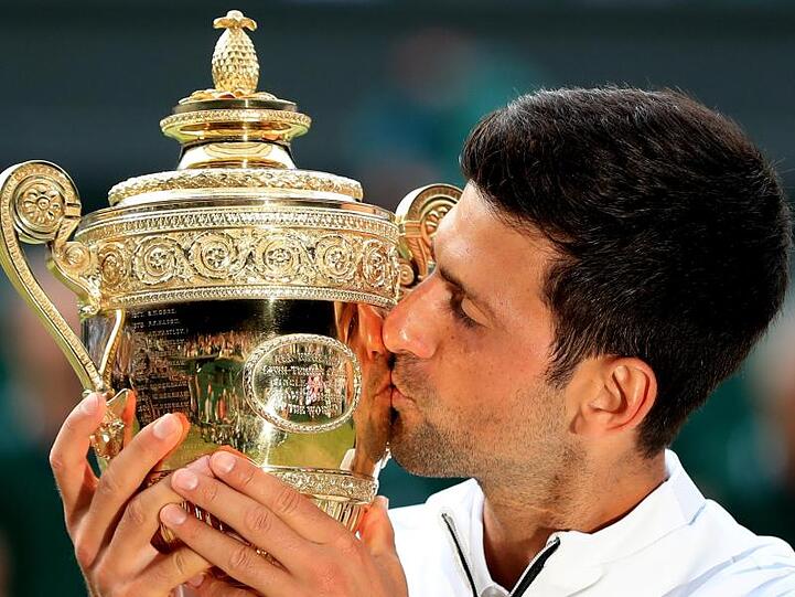 Novak Djokovic küsst bei der Siegerehrung die Trophäe für den Finalgewinner.