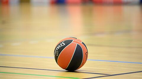 Ein Ball liegt auf einem Basketball-Spielfeld.
