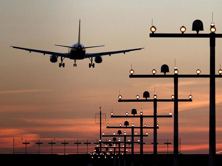 Ein Flugzeug ist während des Sonnenuntergangs im Landeanflug auf den Flughafen.