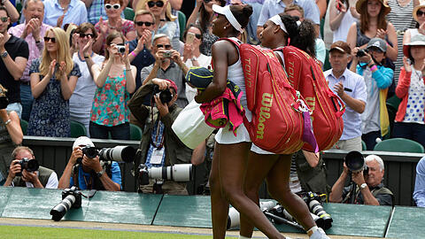 Serena Williams und ihre Schwester Venus Williams verlassen nach ihrem Match den Court von Wimbledon.