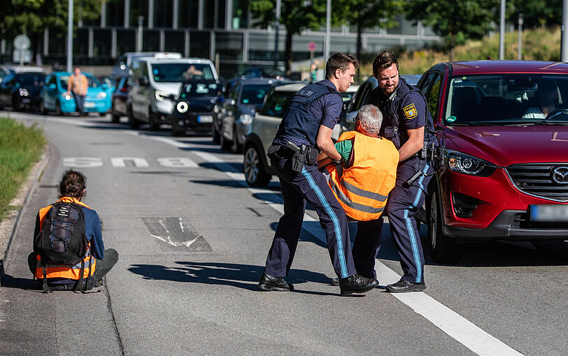 IAA-Protest in München: Polizisten entfernen Klimaaktivisten der Gruppe "Letzte Generation" von der Straße.