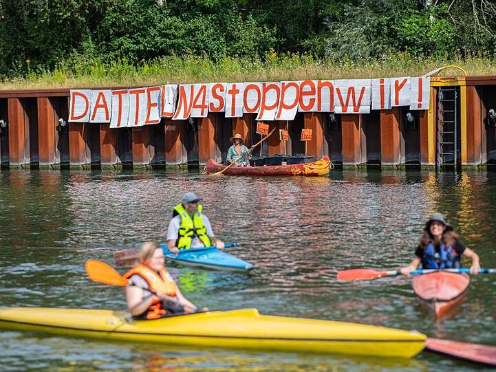 Klimaaktivisten paddeln mit ihren Kanus auf dem Dortmund-Ems-Kanal vor dem Steinkohlekraftwerk Datteln 4.