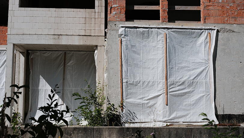 Fenster und Türen sind mit Planen verhangen. Früher gab es hier Geschäfte und Restaurants – und Wohnungen. Fenster und Türen sind mit Planen verhangen. Früher gab es hier Geschäfte und Restaurants – und Wohnungen.