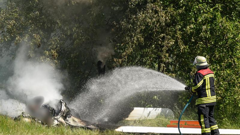 Ein Feuerwehrmann löscht an der Absturzstelle die letzten Glutreste. Ein Feuerwehrmann löscht an der Absturzstelle die letzten Glutreste.
