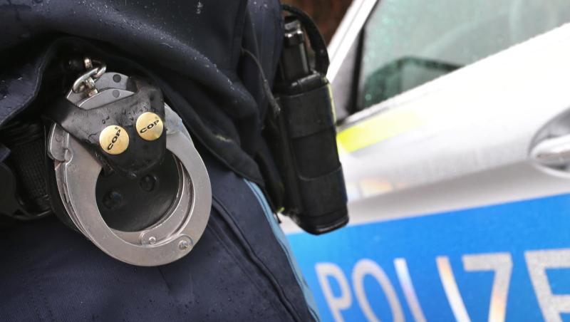 Ein Polizist mit Handschellen und einer Pistole am Gürtel steht vor einem Streifenwagen. Foto: Karl-Josef Hildenbrand/Archivbild Ein Polizist mit Handschellen und einer Pistole am Gürtel steht vor einem Streifenwagen. Foto: Karl-Josef Hildenbrand/Archivbild