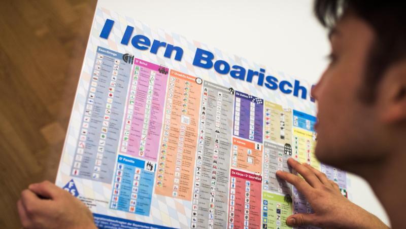 Ein Mann liest die Sprachtafel "I lern Boarisch". Foto: Alexander Heinl/dpa Ein Mann liest die Sprachtafel "I lern Boarisch". Foto: Alexander Heinl/dpa
