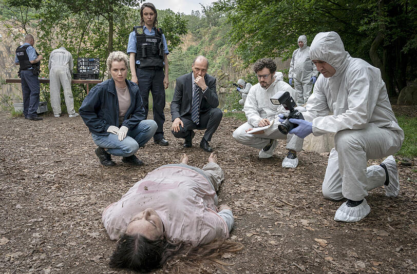 Leonie Winkler (Cornelia Gröschel), Polizistin Antje (Victoria Schulz), Peter Schnabel (Martin Brambach) und Dr. Himpe (Ron Helbig) inspizieren die Tote Lilly-Marie Reuter (Dilara Aylin Ziem) am Leichen-Fundort.