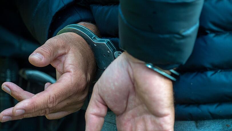 Ein Mann trägt Handschellen. (Symbolbild)