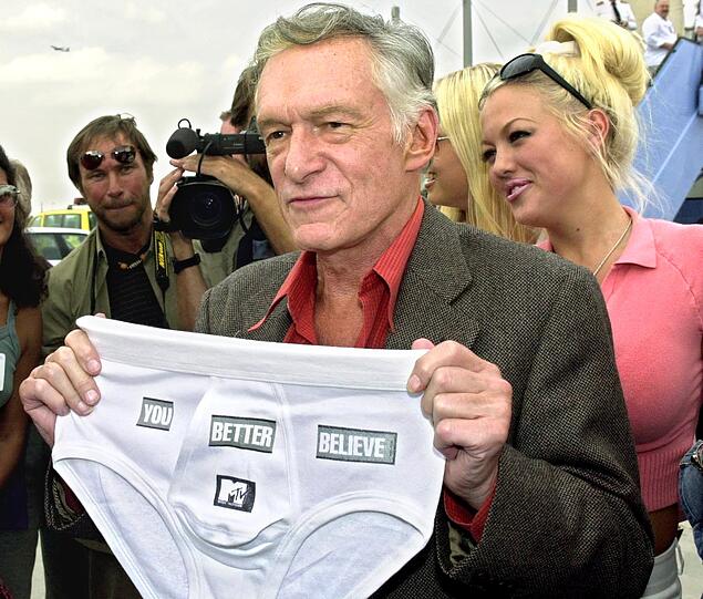 Hugh Hefner anno 2001 mit einer Herrenunterhose am Münchener Flughafen, die er zuvor von einem Reporter als Geschenk erhalten hatte.