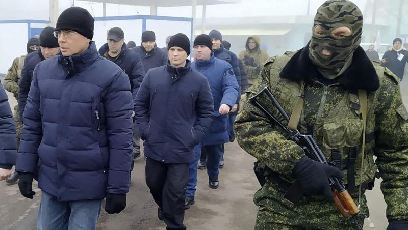 Ein Separatistensoldat begleitet ukrainische Kriegsgefangene zum Kontrollpunkt. Ein Separatistensoldat begleitet ukrainische Kriegsgefangene zum Kontrollpunkt.