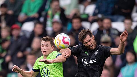 Wolfsburgs Jakub Kaminski (l) beim Kopfballduell mit Gladbachs Joe Scally.